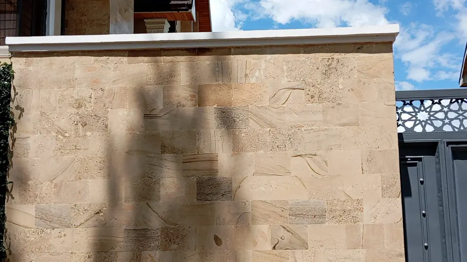 Smooth stone cladding on a boundary wall