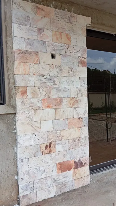 Smooth multi-coloured stone cladding on a column beside a window